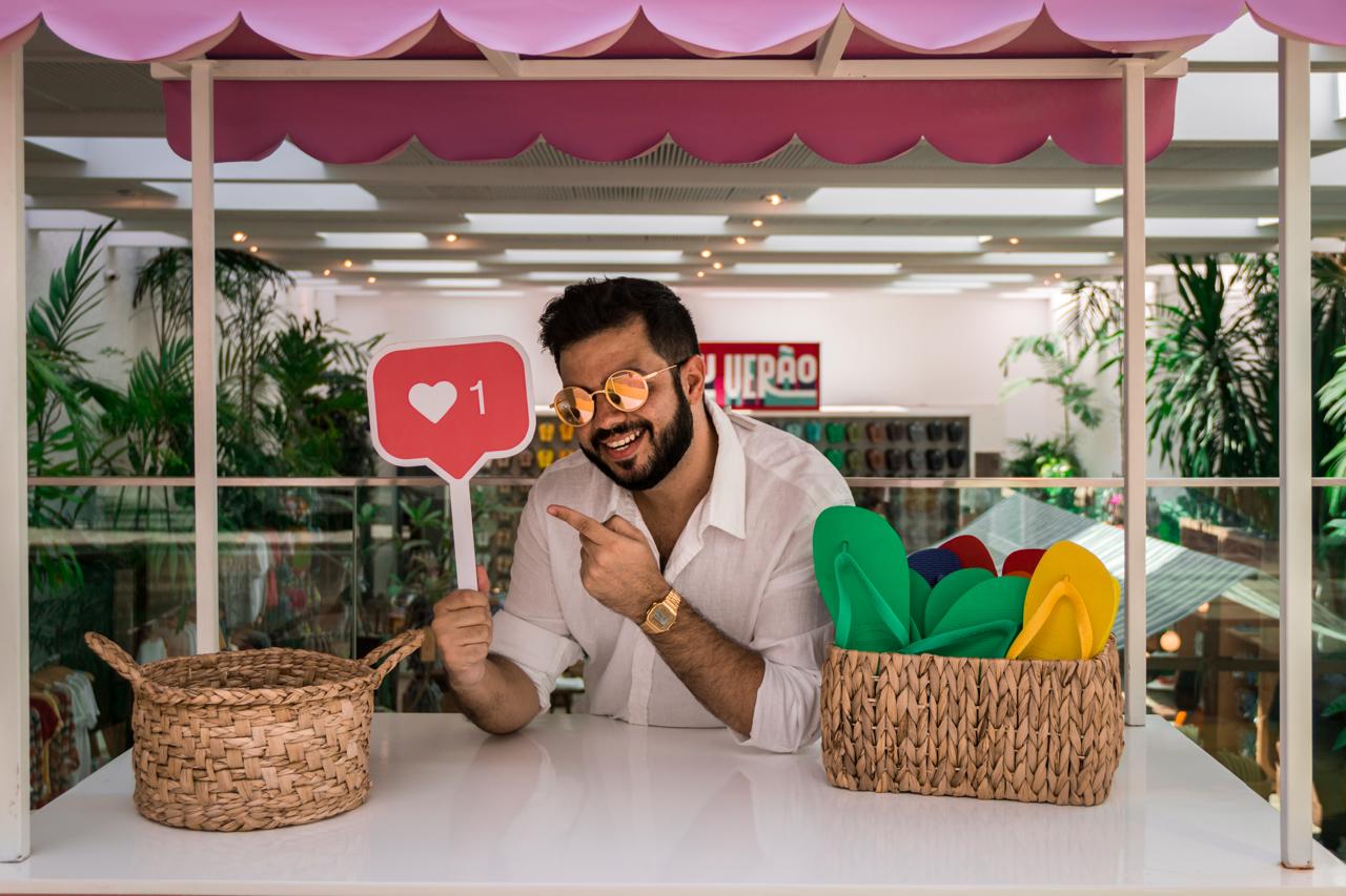 Júnior Nascimento sorrindo segurando uma placa de curtida do Instagram